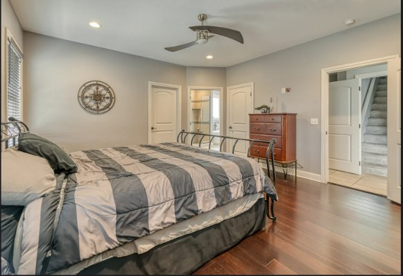 Primary bedroom with staircase to the finished lower level